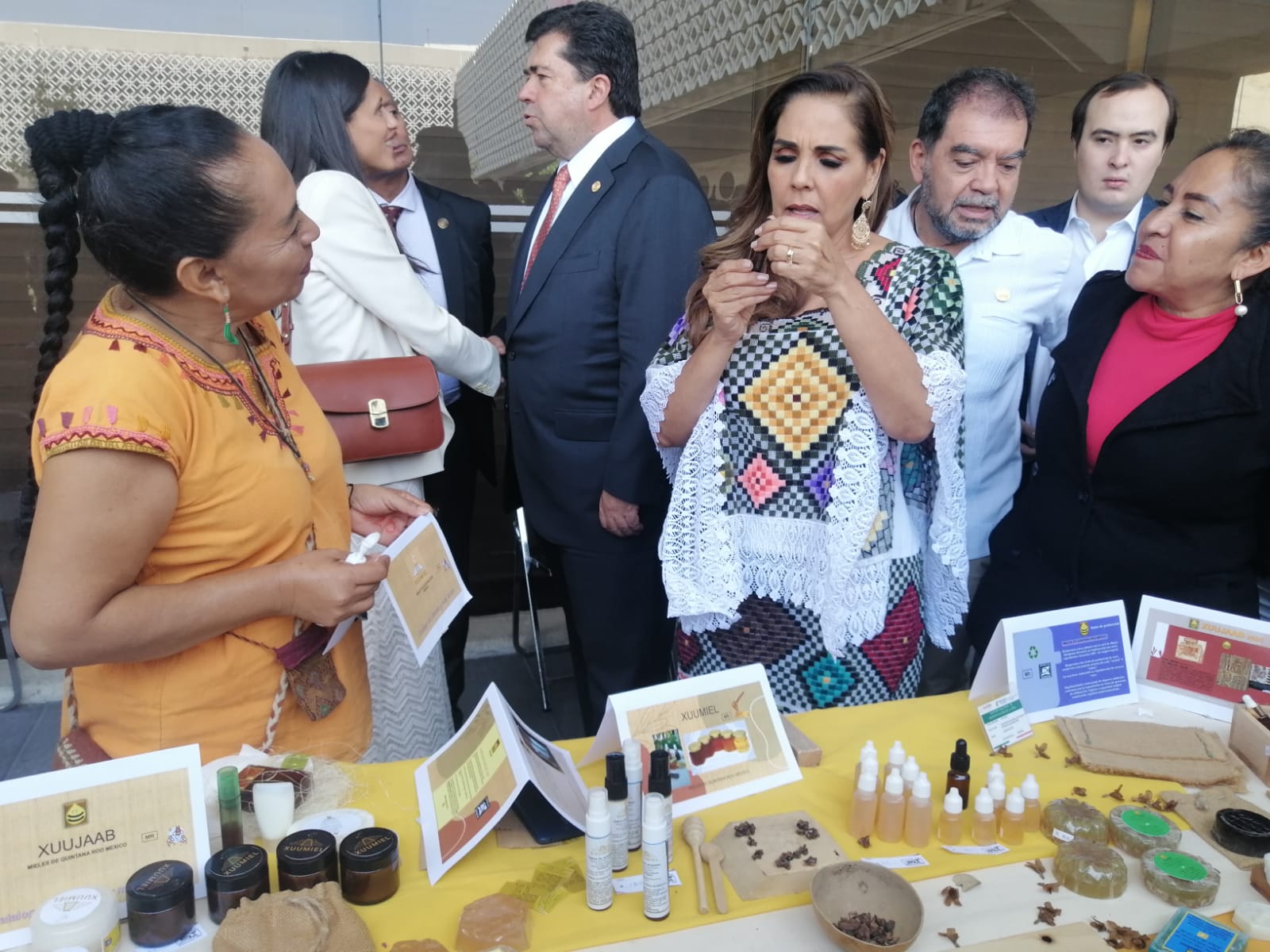 Visitantes probando los productos XUUMIEL en el stand del evento